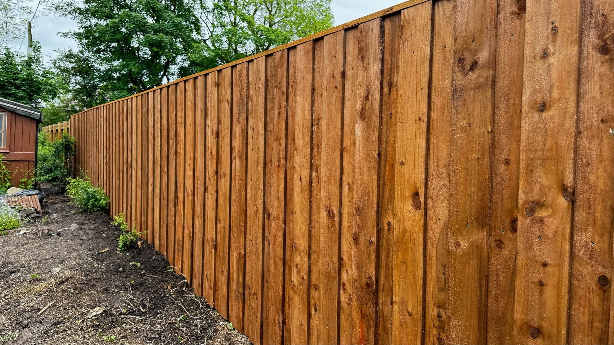 Professional wooden fence installation with vertical boards